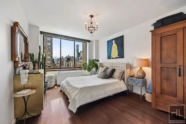 a bedroom with a large bed and a chandelier