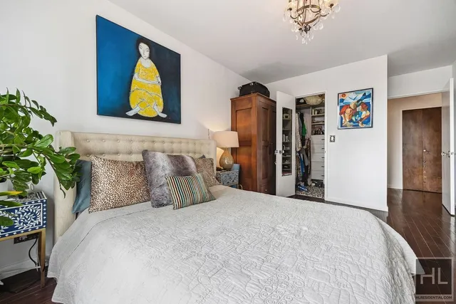 a bedroom with a bed and painting on the wall