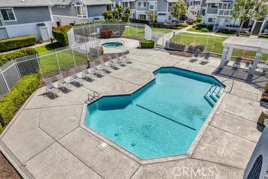 a view of a swimming pool with lawn chairs and plants