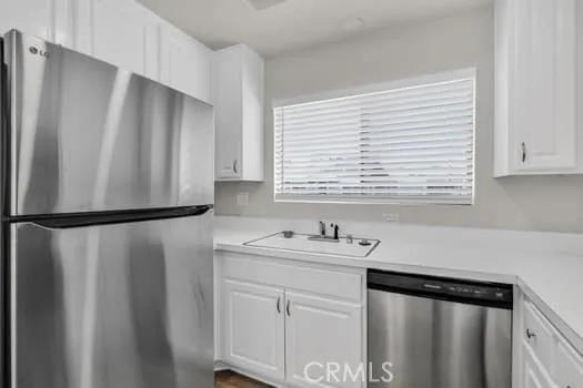 a kitchen with stainless steel appliances a refrigerator sink and cabinets