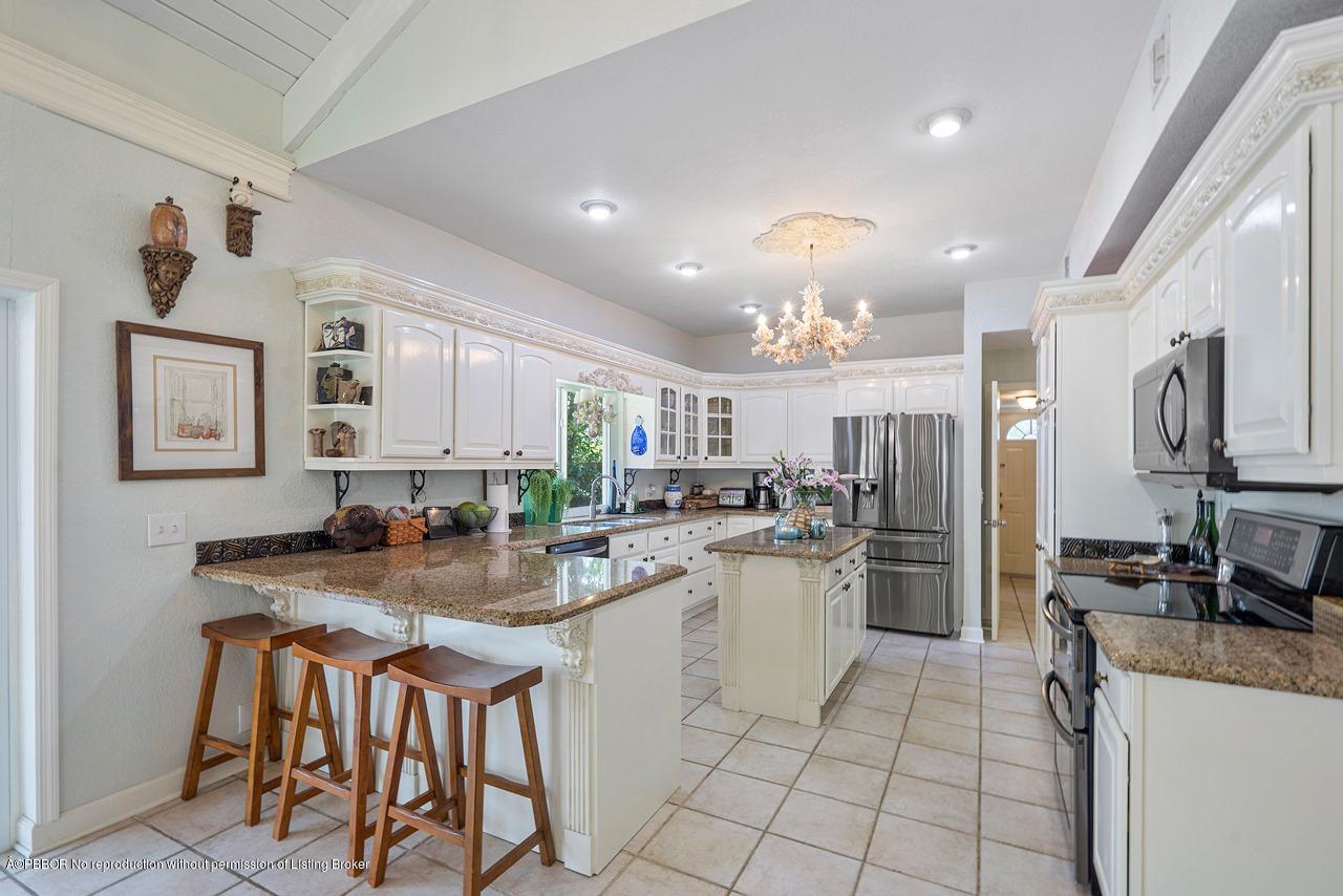 15 East Ocean Avenue Ocean Ridge, FL 33435 - Photo 13 of 31 a kitchen with stainless steel appliances granite countertop a stove top oven a sink dishwasher and a refrigerator