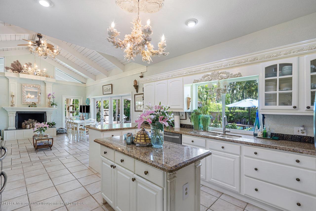 15 East Ocean Avenue Ocean Ridge, FL 33435 - Photo 14 of 31 a kitchen with kitchen island granite countertop a center island a stove cabinets dining table and chairs