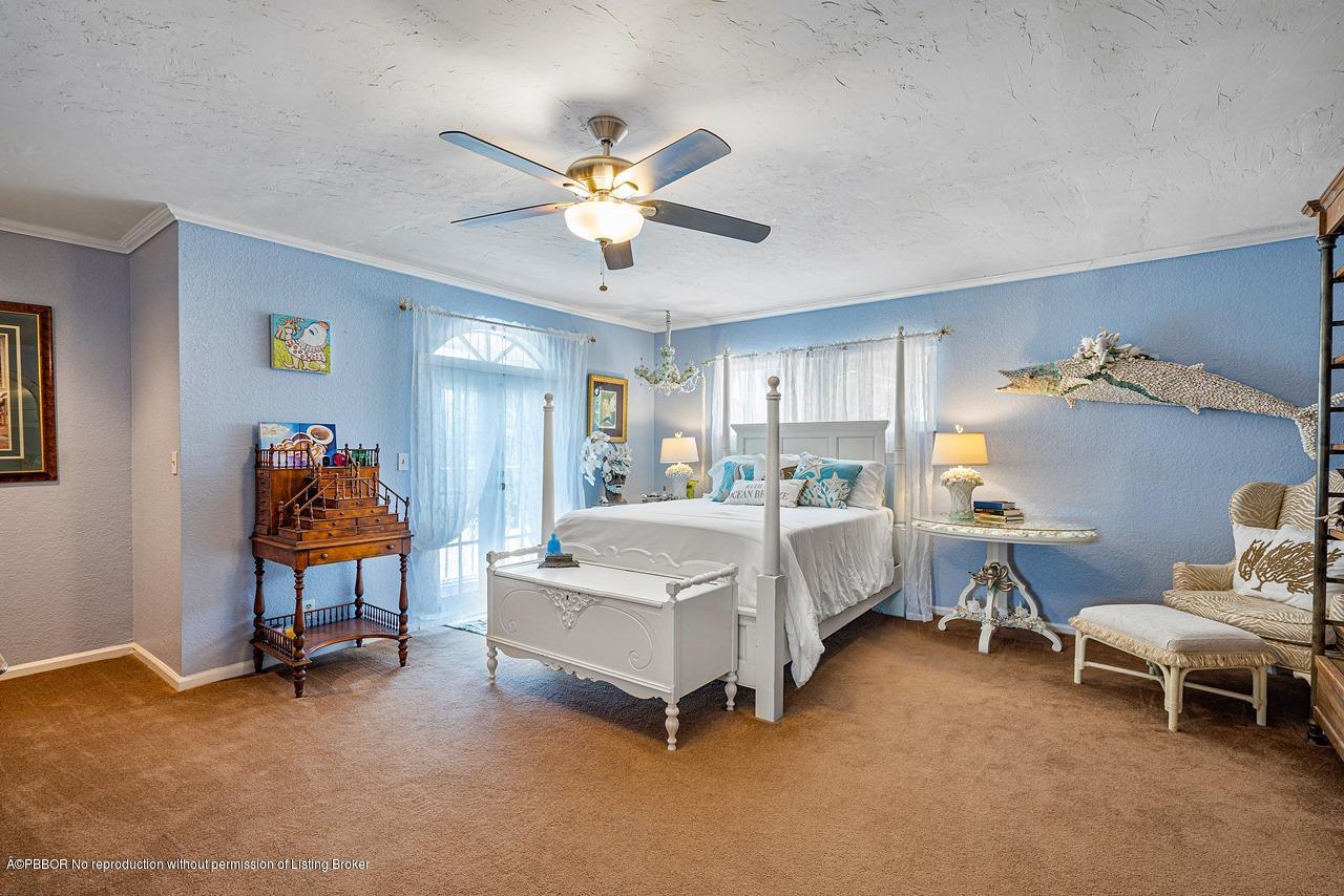 15 East Ocean Avenue Ocean Ridge, FL 33435 - Photo 18 of 31 a bed room with a bed and a chandelier