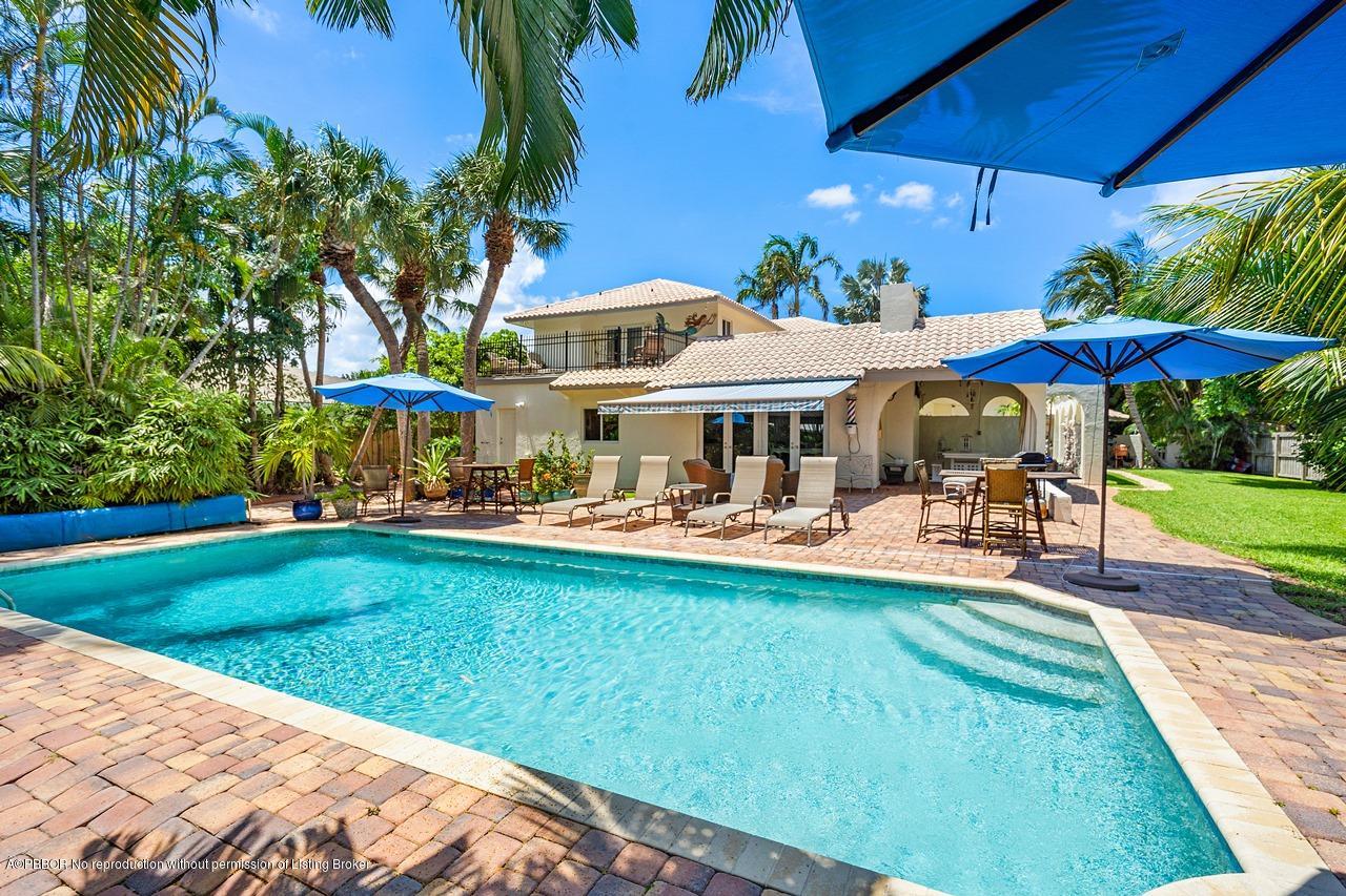 15 East Ocean Avenue Ocean Ridge, FL 33435 - Photo 24 of 31 a view of a swimming pool with lawn chairs under an umbrella