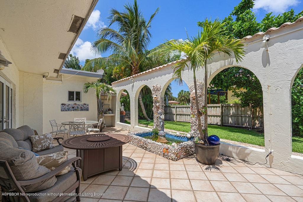 15 East Ocean Avenue Ocean Ridge, FL 33435 - Photo 29 of 31 a view of a patio with table and chairs potted plants and palm tree