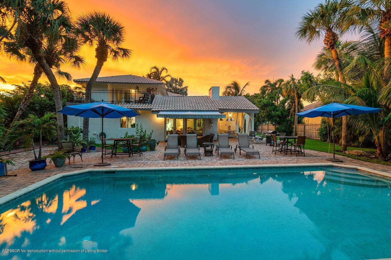 15 East Ocean Avenue Ocean Ridge, FL 33435 - Photo 4 of 31 a view of a swimming pool with a table and chairs under an umbrella