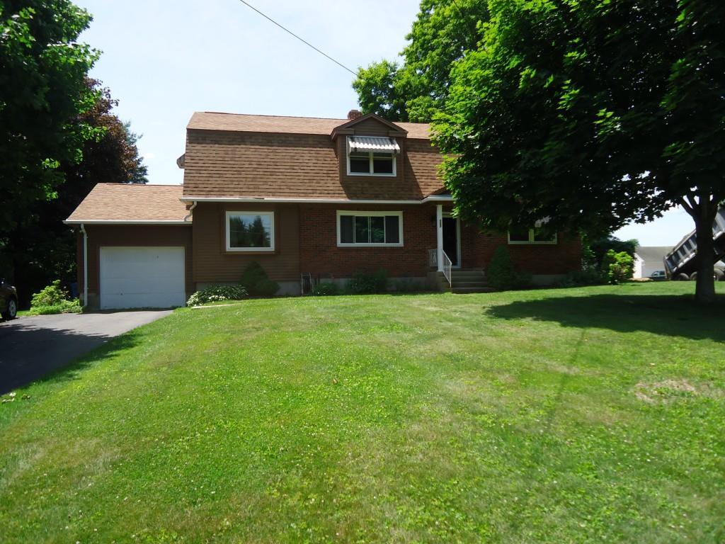 a front view of house with yard and trees