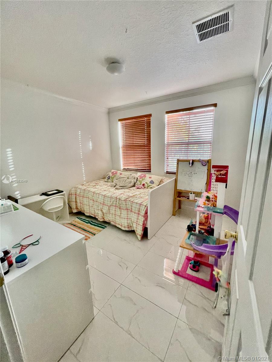 16237 Southwest 48th Street Miramar, FL 33027 - Photo 17 of 28 a bedroom with bed and window
