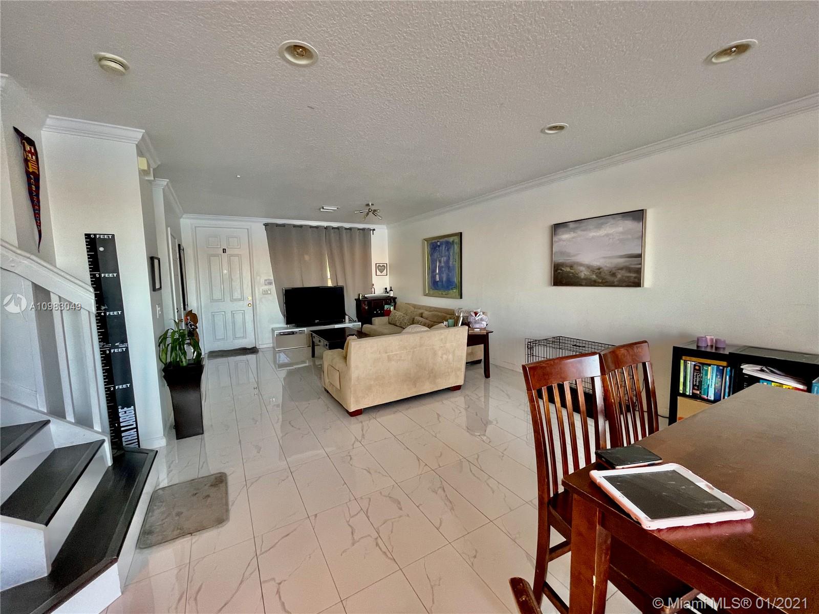 16237 Southwest 48th Street Miramar, FL 33027 - Photo 3 of 28 a living room with furniture fireplace and a flat screen tv
