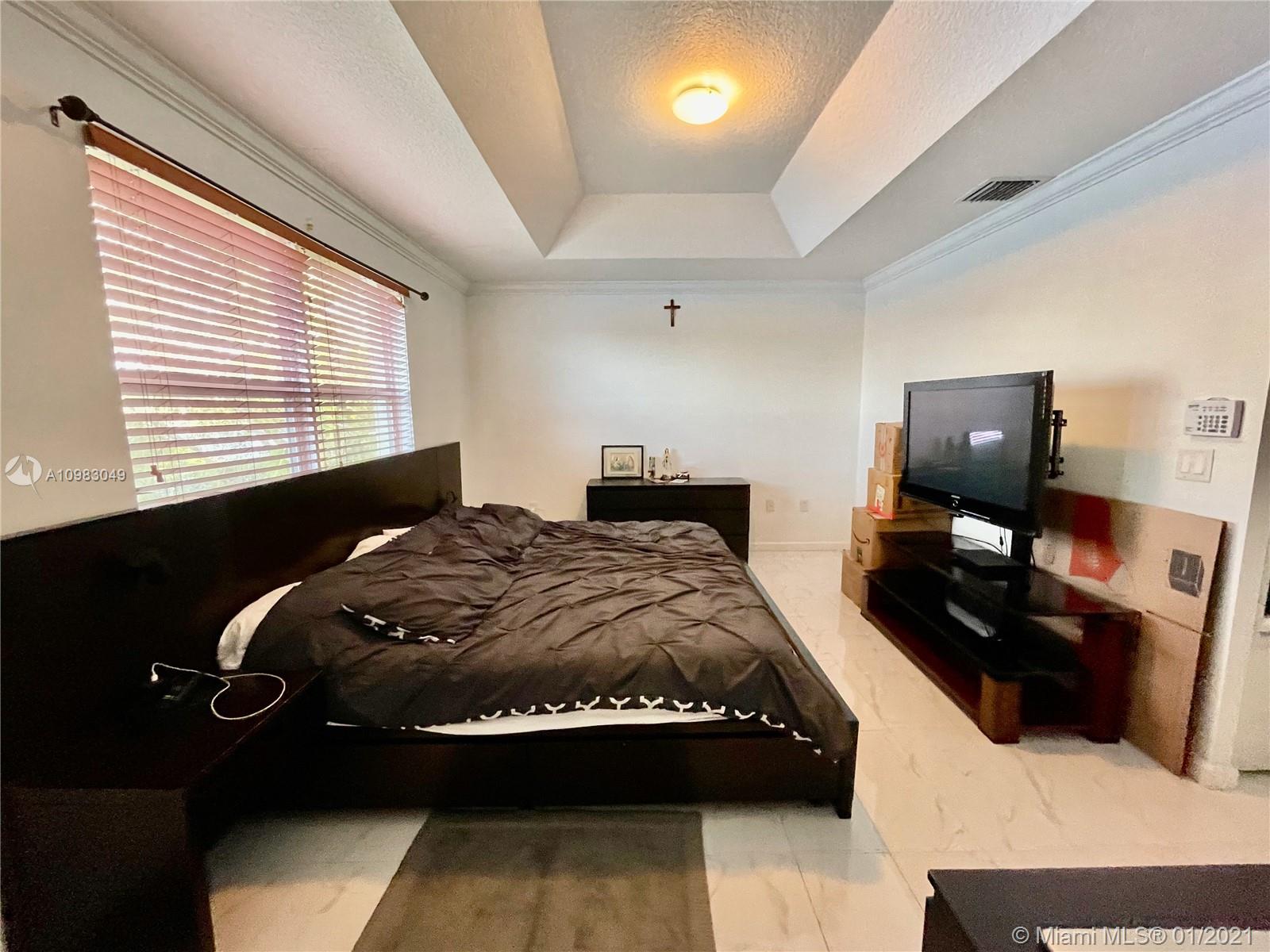 16237 Southwest 48th Street Miramar, FL 33027 - Photo 10 of 28 a bedroom with a bed and a tv