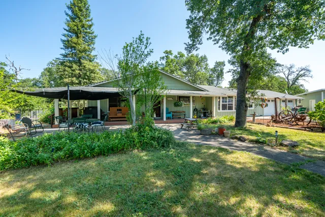 a view of a house with a yard and sitting area