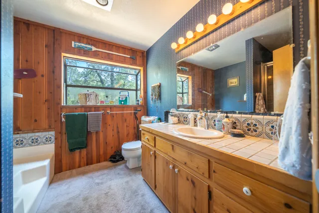 a front view of a house with a garden and trees