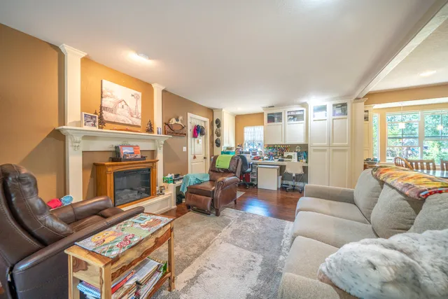 a living room with furniture a fireplace and a large window