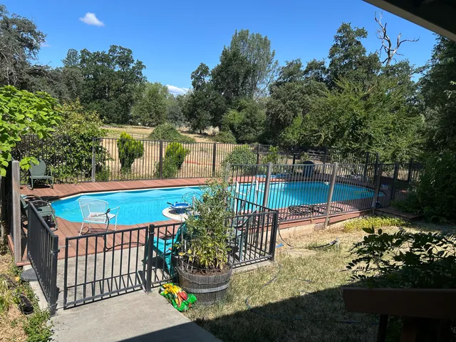 a view of a yard with wooden fence