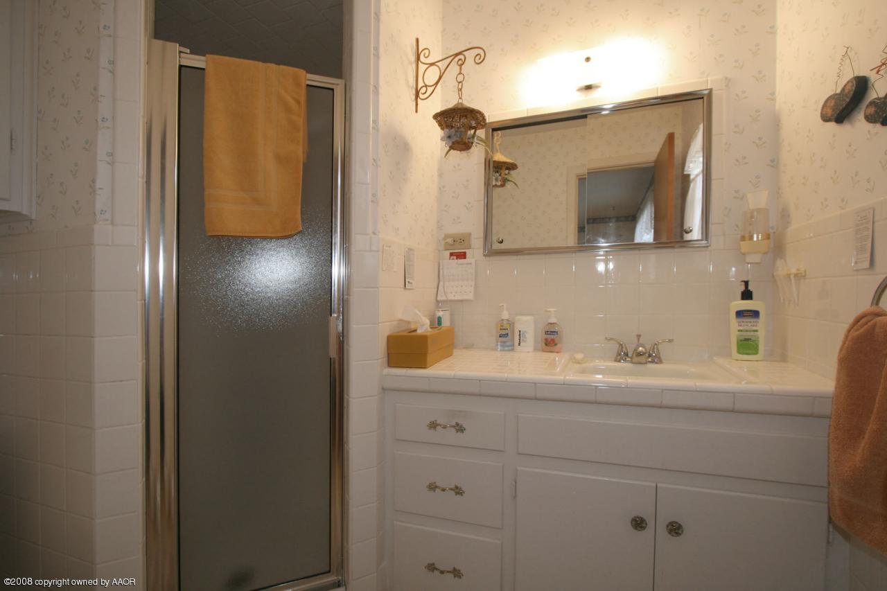 6711 Elmhurst Road Amarillo, TX 79106 - Photo 13 of 15 a bathroom with a sink and a mirror