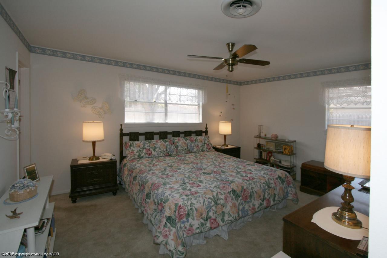 6711 Elmhurst Road Amarillo, TX 79106 - Photo 14 of 15 a bedroom with a bed and a chandelier