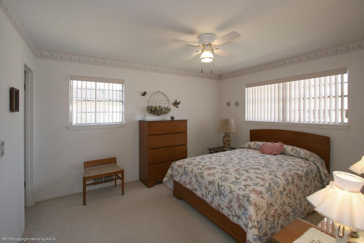 6711 Elmhurst Road Amarillo, TX 79106 - Photo 4 of 15 a bedroom with a bed and a chandelier
