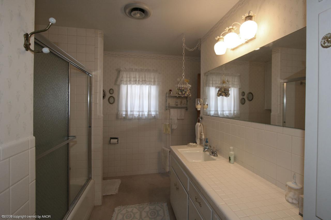 6711 Elmhurst Road Amarillo, TX 79106 - Photo 9 of 15 a bathroom with a double vanity sink mirror and shower