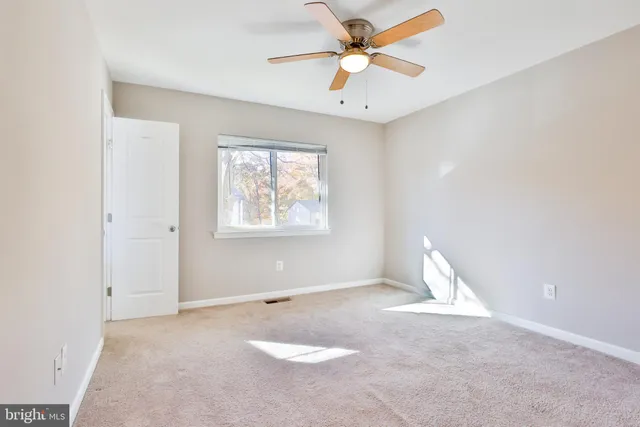 an empty room with closet and a chandelier fan