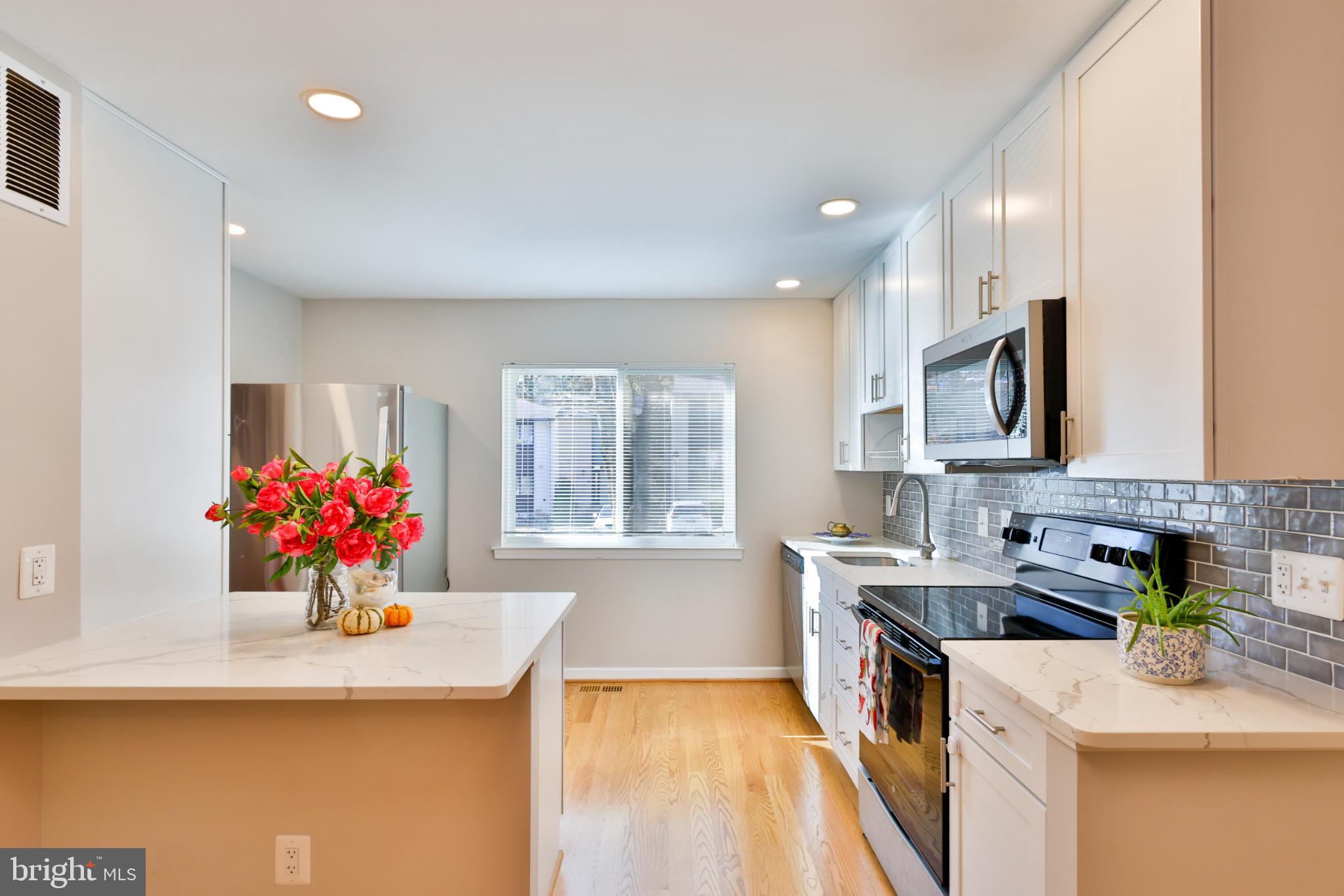 11817 Coopers Court Reston, VA 20191 - Photo 3 of 58 a kitchen with stainless steel appliances kitchen island granite countertop a sink stove and cabinets