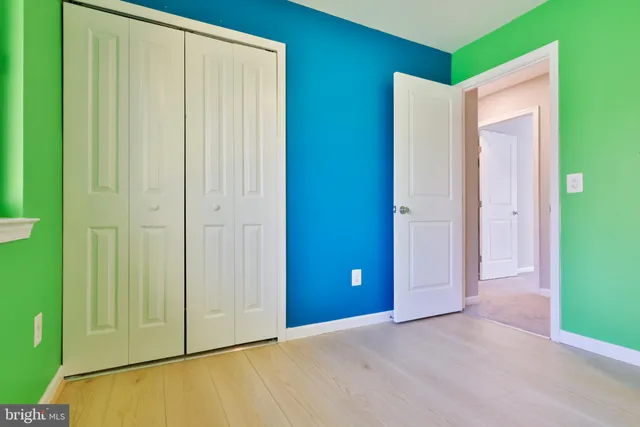 a view of empty room with wooden floor and windows