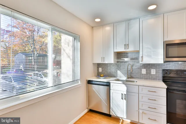 a kitchen with granite countertop white cabinets and a window