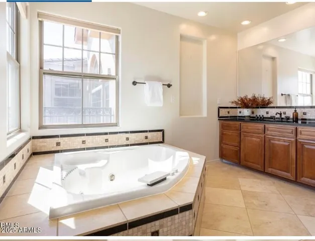 a bathroom with a tub sink and mirror
