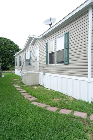 a view of house with backyard and a garden