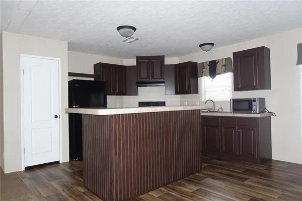 a kitchen with stainless steel appliances granite countertop a refrigerator and a stove top oven