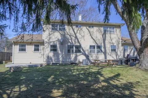 a view of backyard with large tree and wooden fence