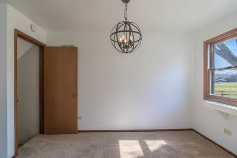 a view of empty room with window and wooden floor
