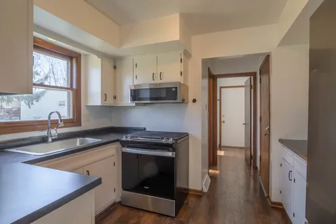 a kitchen with stainless steel appliances granite countertop a stove a sink and a refrigerator