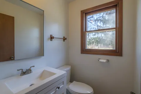 a bathroom with a toilet a sink and mirror