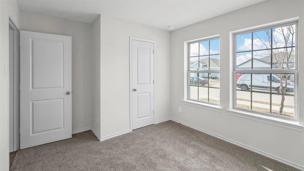 1953 Freeman Street Tyler, TX 75704 - Photo 19 of 32 Bright room with two white-framed windows, neutral carpet flooring, and two interior doors with silver hardware