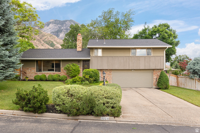 3320 Cherokee Lane Provo, UT 84604 - Photo 1 of 52 Split-level residence featuring a two-car garage with a concrete driveway and mature landscaping