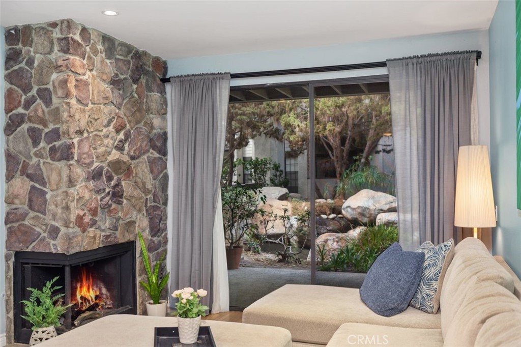 The living room boasts a cozy fireplace and offers a direct view of a waterfall through the sliding door.