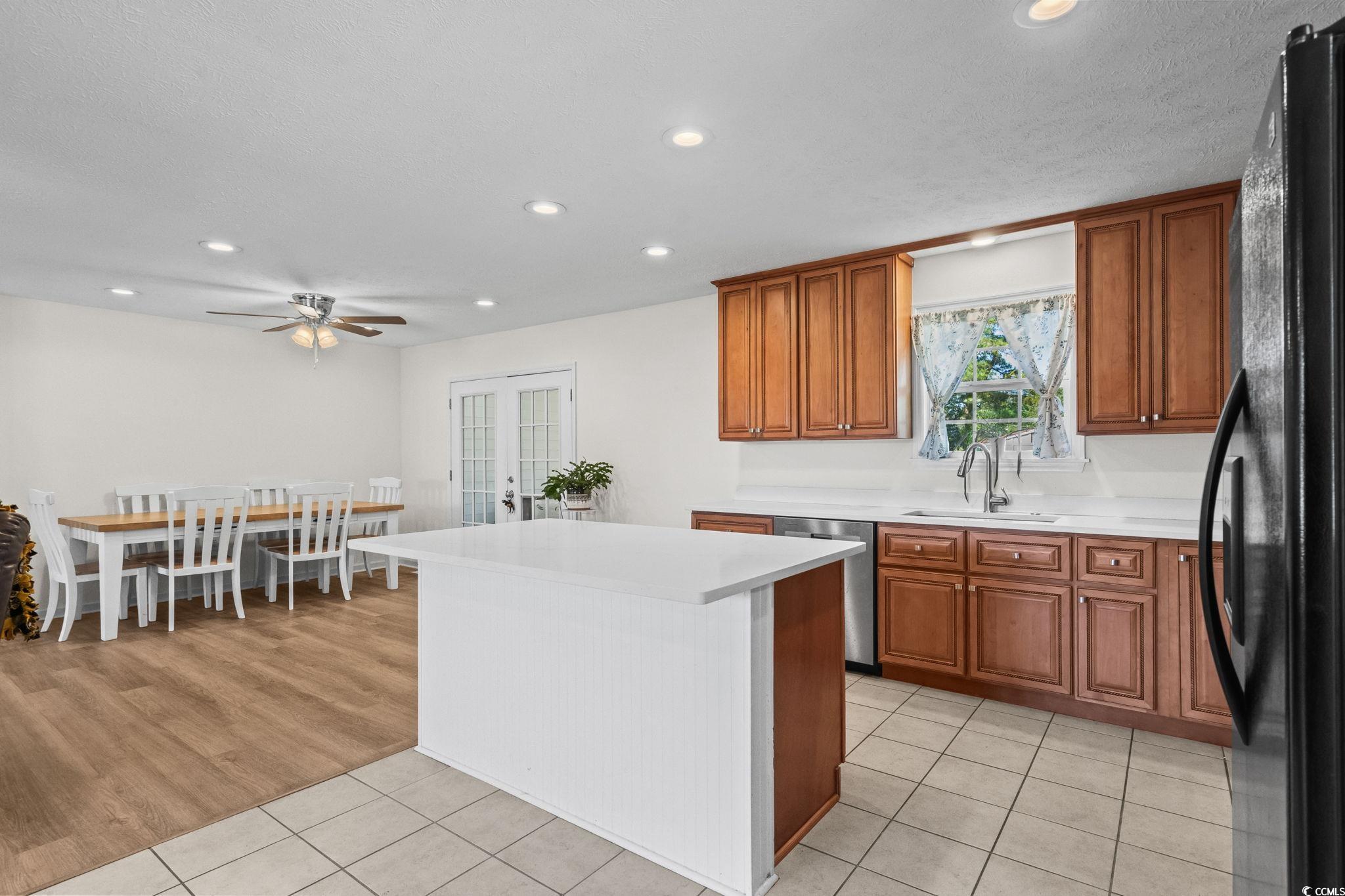 1996 Heritage Road Loris, SC 29569 - Photo 12 of 40 Kitchen with brown cabinetry, freestanding refrigerator, a kitchen island, recessed lighting, and light tile patterned floors
