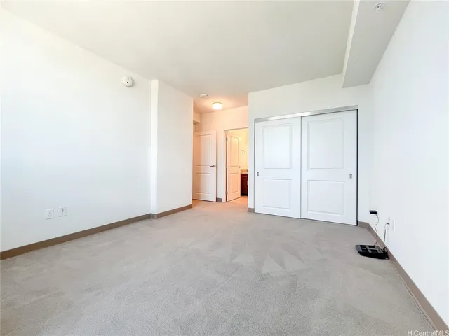 an empty room with a cabinet and mirrors