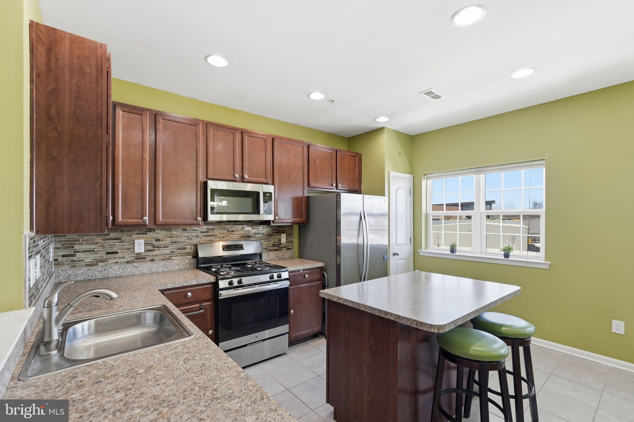 153 Mercer Court Fairless Hills, PA 19030 - Photo 4 of 29 a kitchen with kitchen island granite countertop a sink stainless steel appliances and cabinets