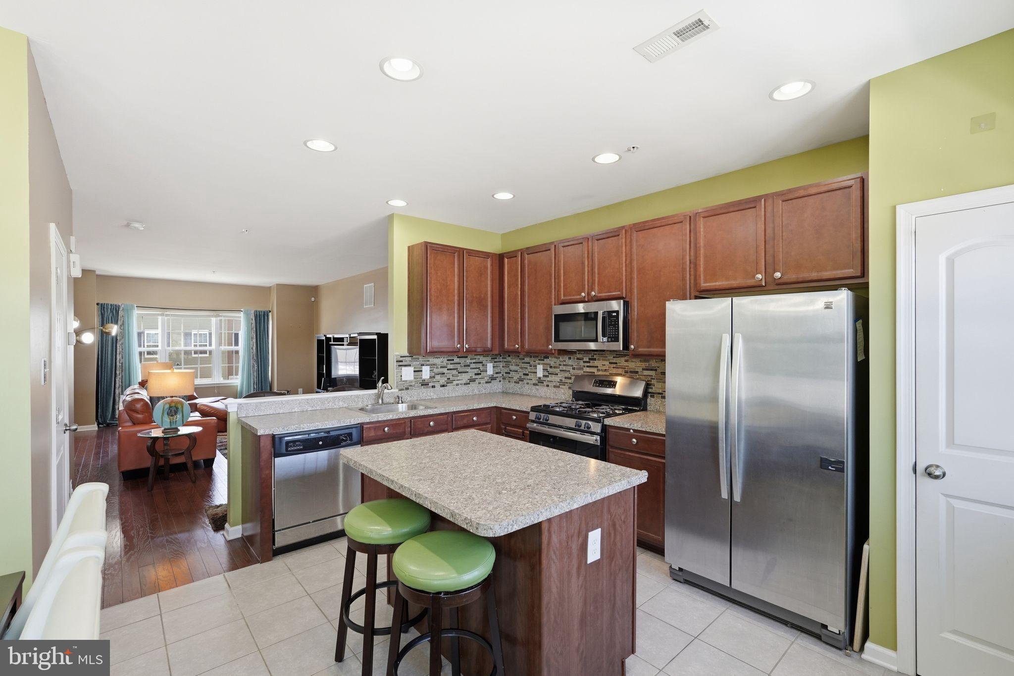 153 Mercer Court Fairless Hills, PA 19030 - Photo 6 of 29 a kitchen with kitchen island a counter top space appliances and a refrigerator