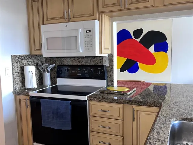 a kitchen with granite countertop cabinets and a stove