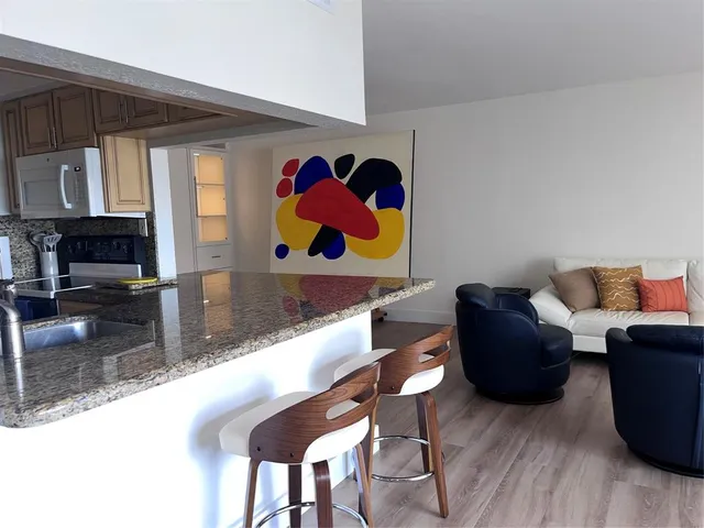 a living room with furniture and a kitchen view