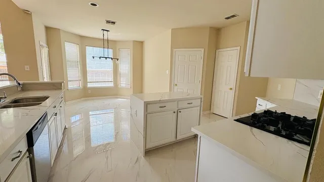 a kitchen with white cabinets and a stove