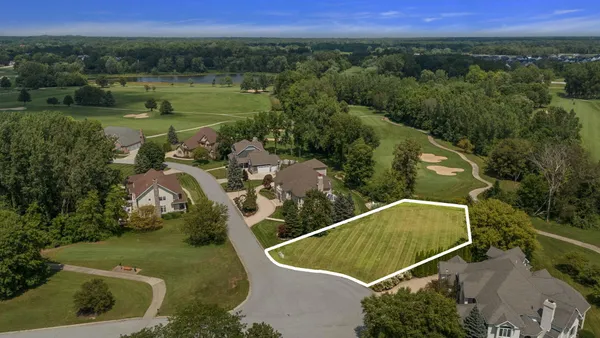an aerial view of a house with a yard and lake view