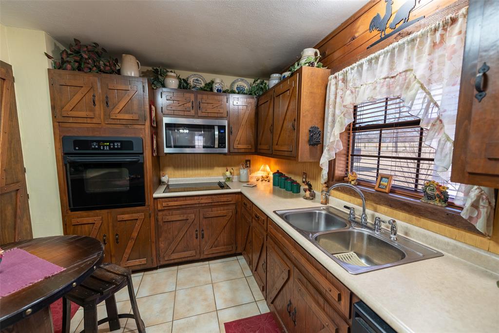 419 County Road Southeast Scroggins, TX 75480 - Photo 13 of 30 a kitchen with granite countertop a sink and cabinets