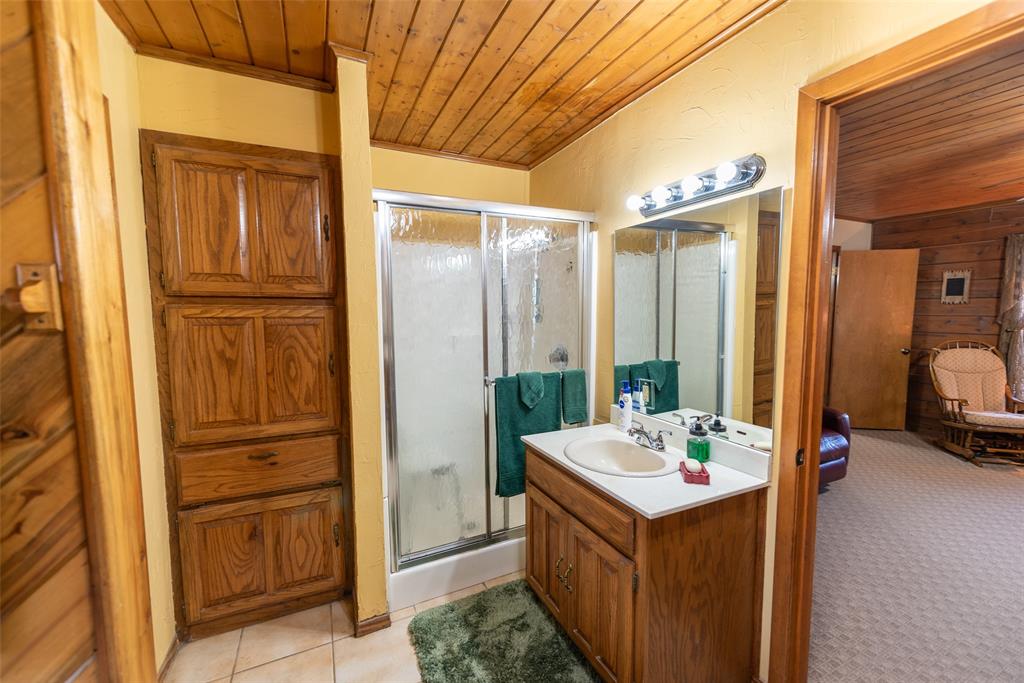 419 County Road Southeast Scroggins, TX 75480 - Photo 19 of 30 a bathroom with a tub sink vanity and mirror