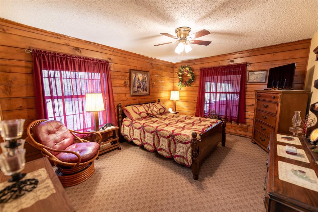 419 County Road Southeast Scroggins, TX 75480 - Photo 22 of 30 a bedroom with a bed and a chandelier