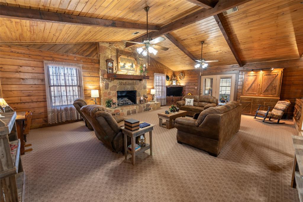 419 County Road Southeast Scroggins, TX 75480 - Photo 5 of 30 a living room with furniture a fireplace and a chandelier