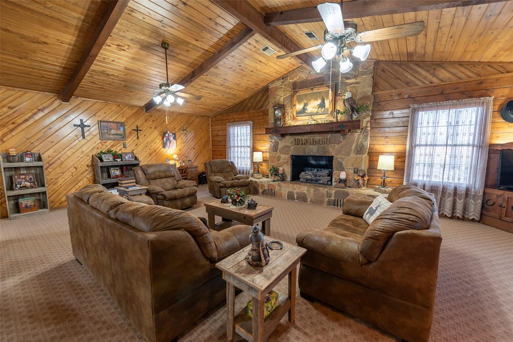 419 County Road Southeast Scroggins, TX 75480 - Photo 8 of 30 a living room with furniture a fireplace and a chandelier