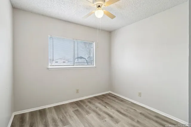 a view of an empty room with a ceiling fan